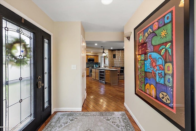 entrance foyer featuring beverage cooler, baseboards, recessed lighting, and wood finished floors