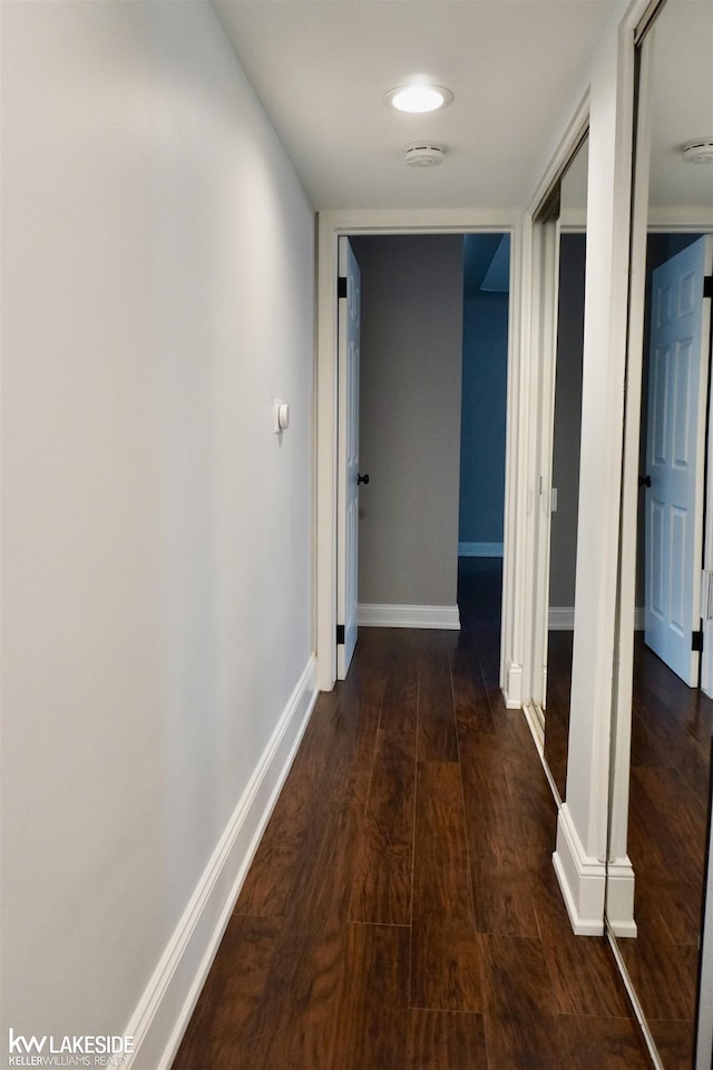 hall with baseboards and dark wood finished floors