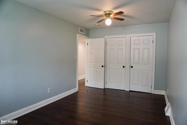 unfurnished bedroom featuring baseboards, visible vents, and dark wood-type flooring