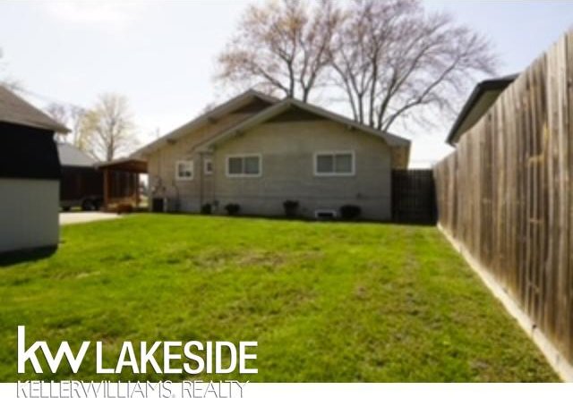 rear view of house featuring a fenced backyard and a yard