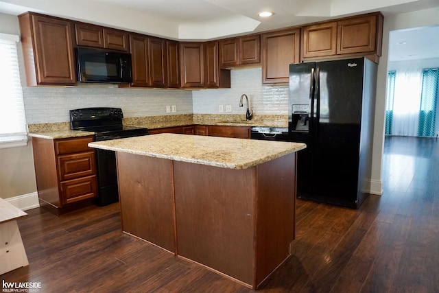 kitchen with a sink, dark wood finished floors, black appliances, and tasteful backsplash