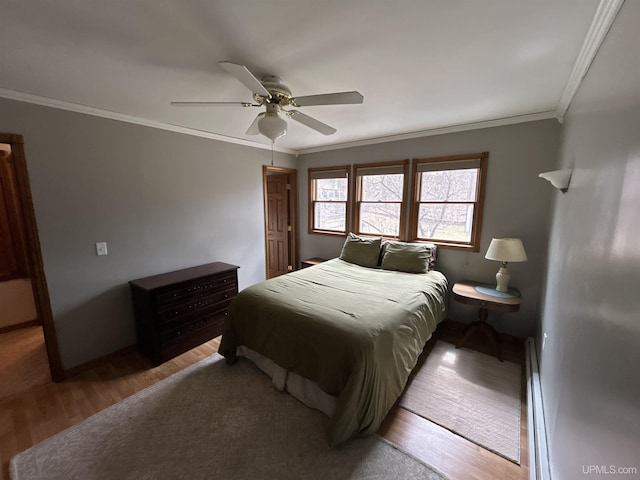 bedroom with baseboards, ornamental molding, light wood-style flooring, and a ceiling fan