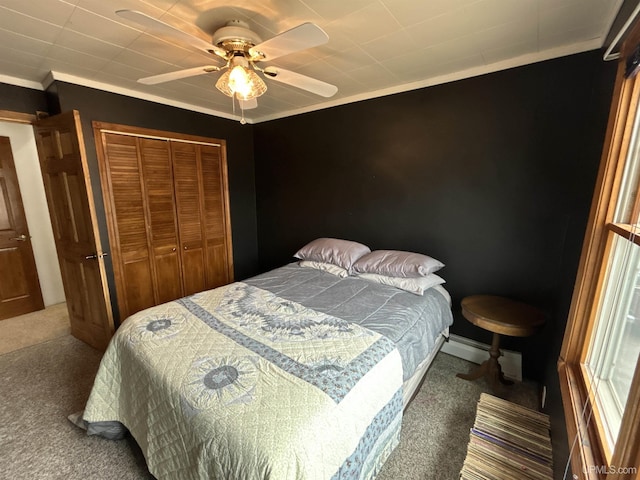 carpeted bedroom featuring a ceiling fan, ornamental molding, and a closet