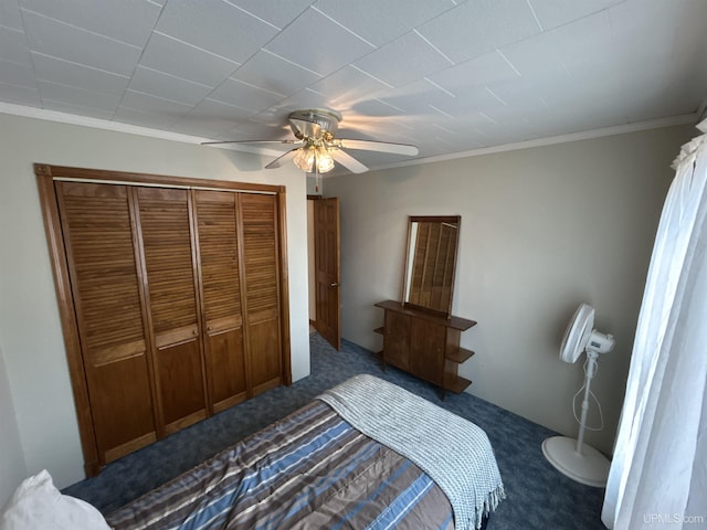 bedroom with a closet, ceiling fan, ornamental molding, and dark colored carpet