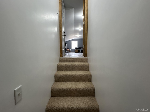 stairway featuring lofted ceiling