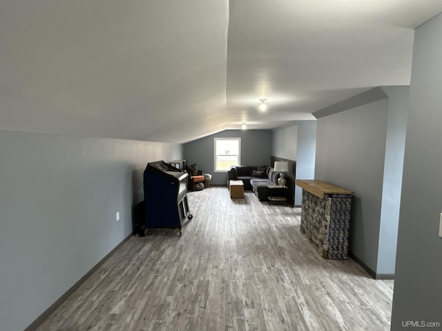 bonus room with baseboards, wood finished floors, and lofted ceiling