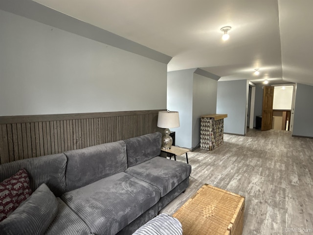 living area with wood finished floors and lofted ceiling