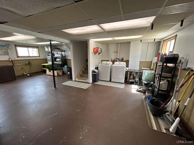 basement with stairway, separate washer and dryer, a paneled ceiling, and a wealth of natural light