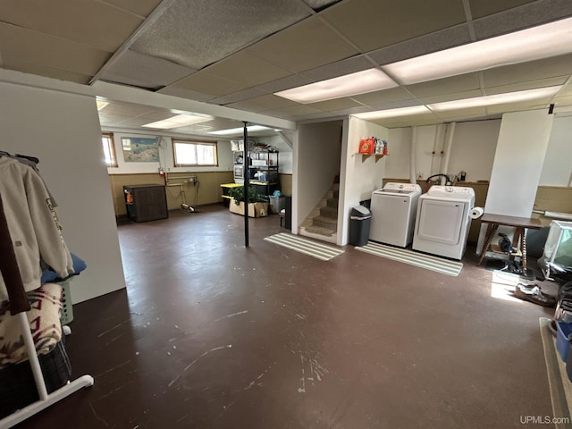 basement featuring washing machine and clothes dryer, a drop ceiling, and stairway