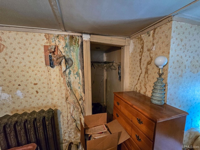 interior space with radiator and wallpapered walls