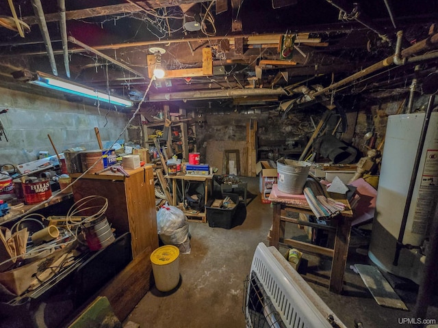 unfinished basement featuring water heater and a workshop area