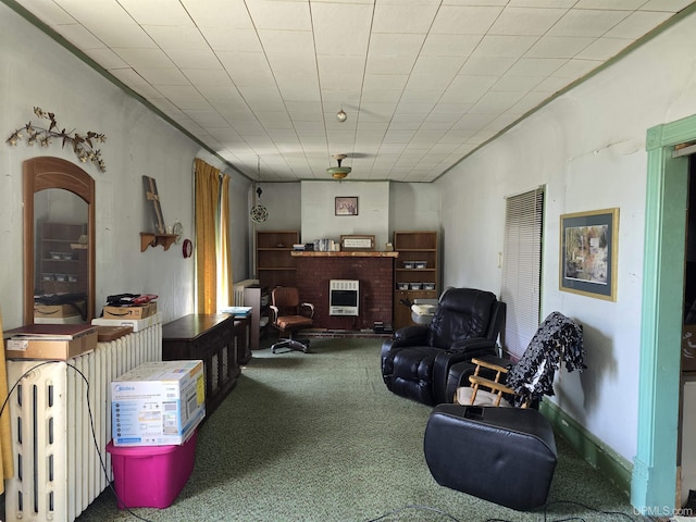 carpeted living area with heating unit and a fireplace