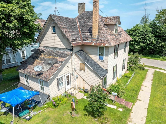 rear view of house with a yard and a chimney