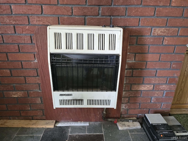 details featuring brick siding and heating unit