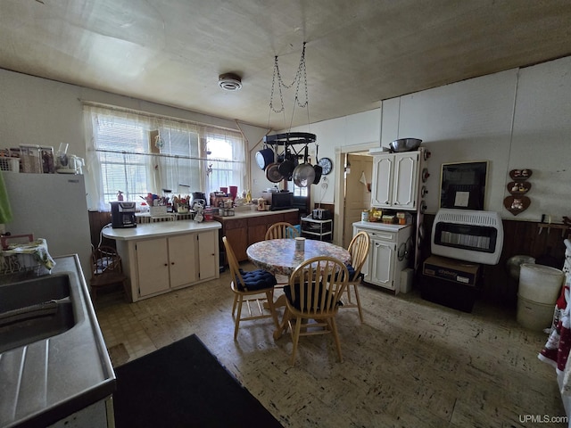 kitchen featuring heating unit, light countertops, and a sink