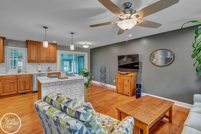 living room with ceiling fan, baseboards, and light wood finished floors