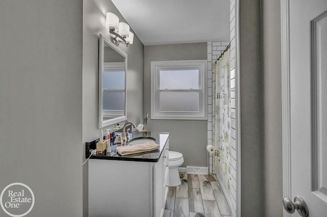 full bath featuring vanity, baseboards, a shower with shower curtain, and toilet