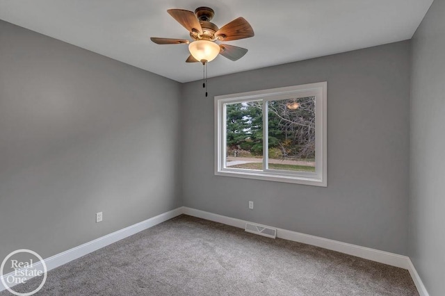 carpeted empty room with baseboards, ceiling fan, and visible vents