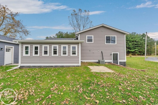 back of house featuring a yard, central AC unit, and a patio area