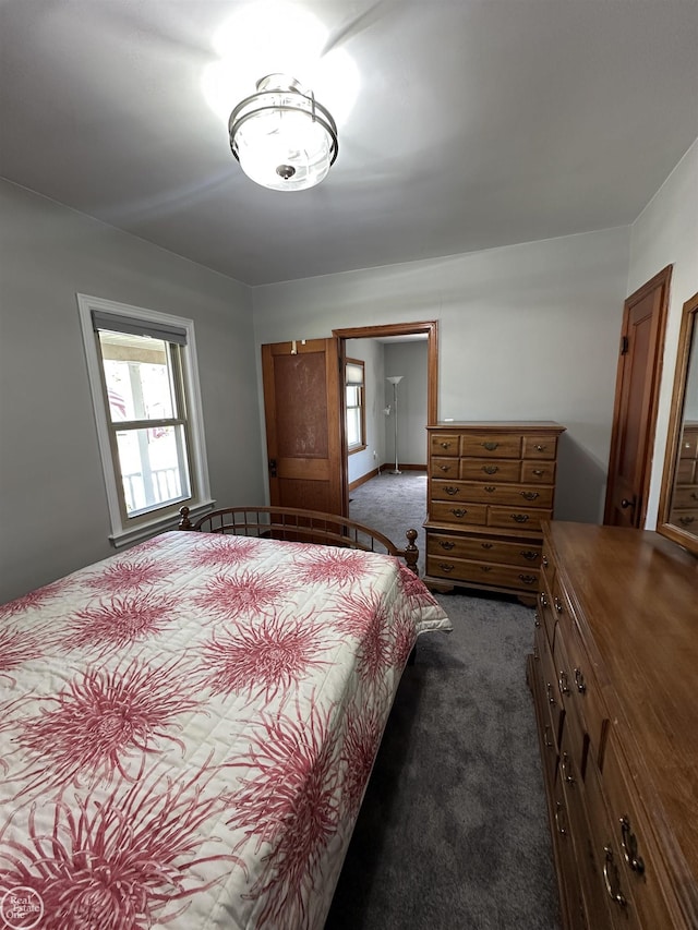 bedroom featuring multiple windows and dark colored carpet
