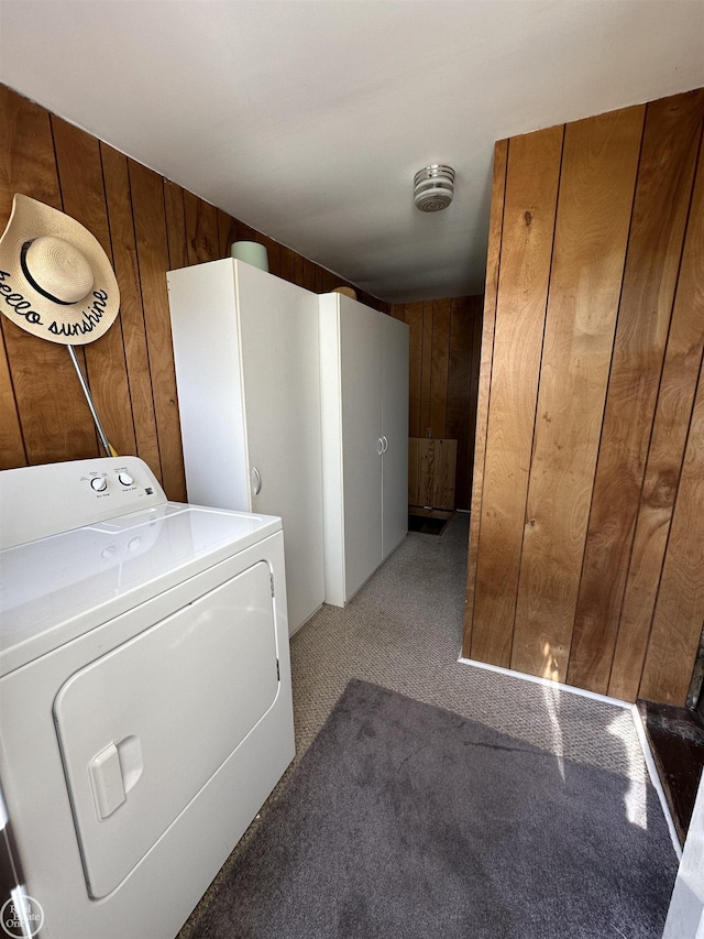 laundry room featuring wooden walls, laundry area, carpet flooring, and washer / clothes dryer