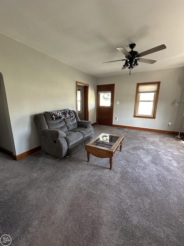 carpeted living area featuring baseboards and ceiling fan