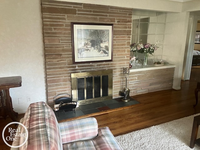 living area featuring a glass covered fireplace and wood finished floors