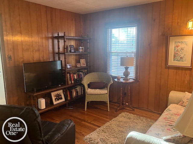 living area featuring wooden walls and wood finished floors