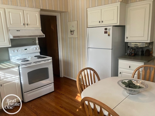 kitchen with white appliances, dark wood-style floors, wallpapered walls, white cabinetry, and under cabinet range hood
