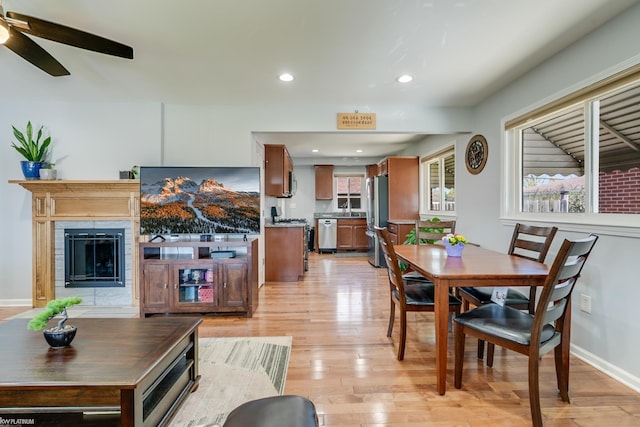 dining room featuring light wood-style floors, a fireplace, a ceiling fan, and recessed lighting