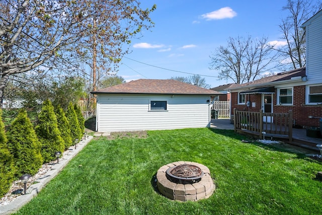 view of yard with an outbuilding, a fire pit, and a deck