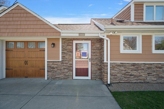 property entrance featuring stone siding and a garage