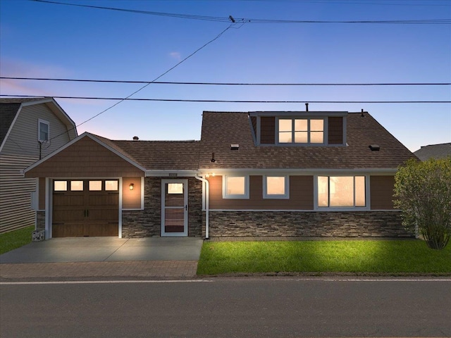 view of front of house featuring a garage, stone siding, and concrete driveway