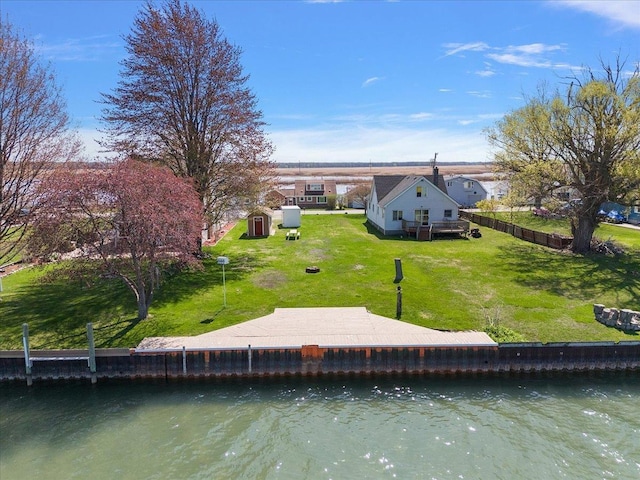 rear view of house with a lawn and a water view
