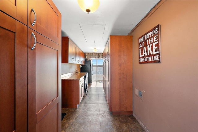 hall with baseboards and attic access