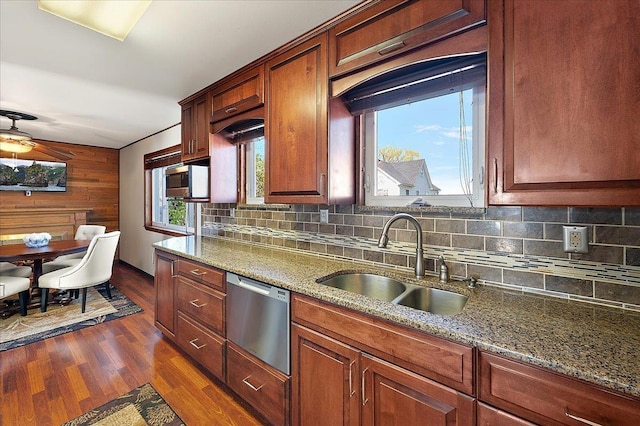 kitchen featuring tasteful backsplash, a sink, light stone counters, dark wood-style floors, and stainless steel appliances