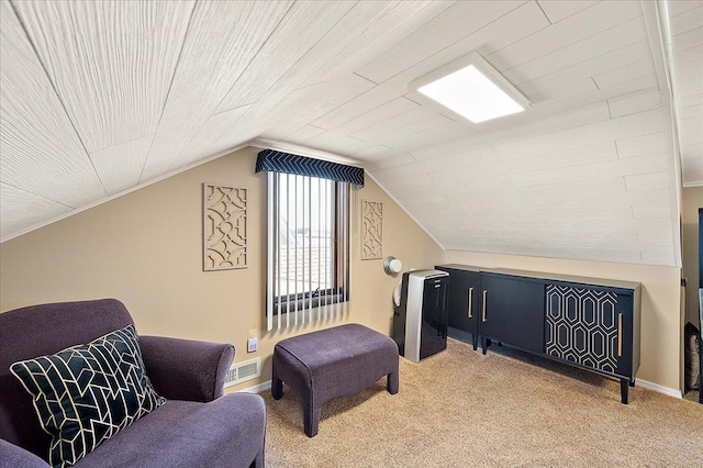 interior space featuring visible vents, baseboards, lofted ceiling, and light carpet