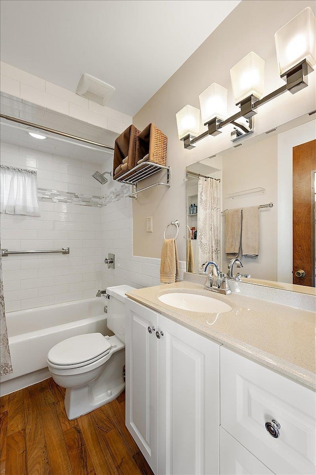 full bathroom featuring vanity, toilet, wood finished floors, and shower / tub combo with curtain