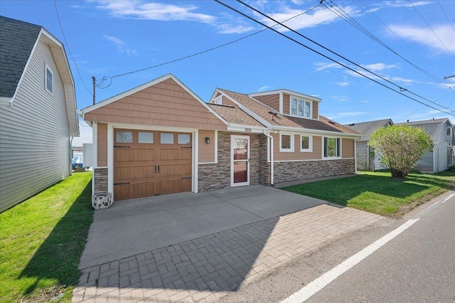 view of front facade featuring an attached garage, concrete driveway, a front lawn, and stone siding