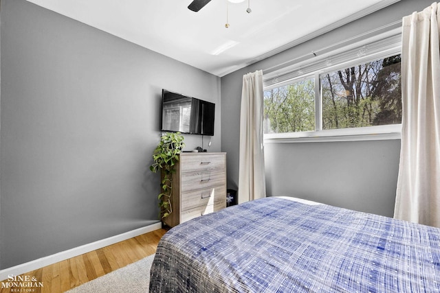 bedroom with baseboards, ceiling fan, and wood finished floors