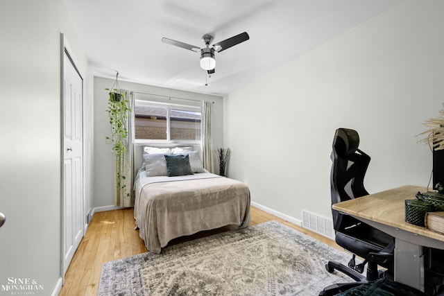 bedroom featuring a ceiling fan, baseboards, visible vents, and light wood-style floors