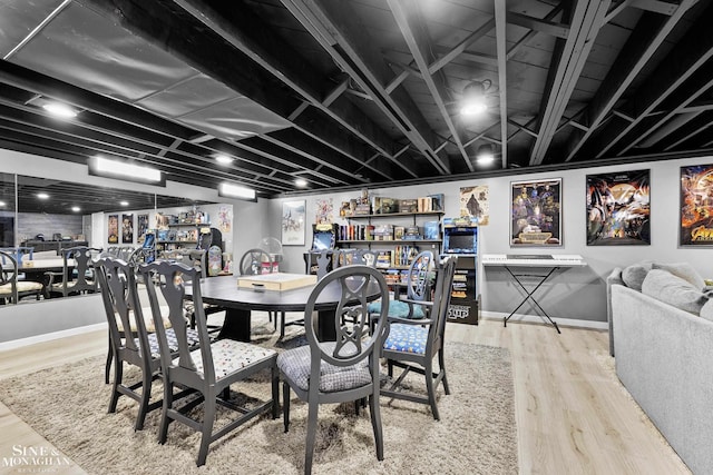 dining space with baseboards and wood finished floors