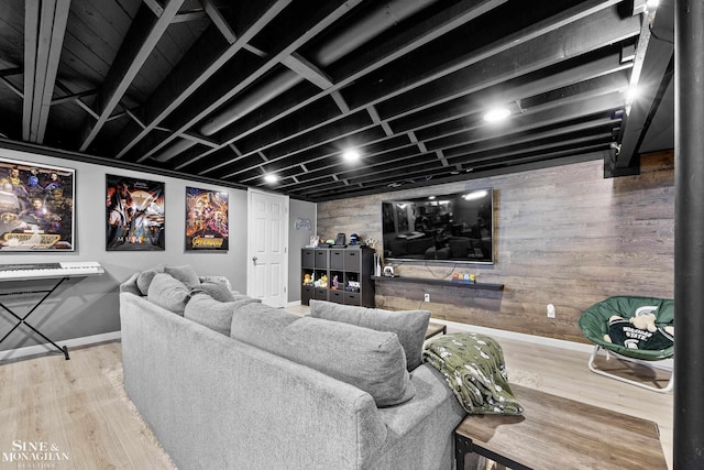 home theater with baseboards, wood walls, and wood finished floors