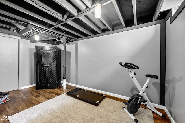 workout area with baseboards and wood finished floors