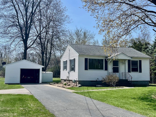 view of front of home with a detached garage, an outdoor structure, roof with shingles, and a front yard
