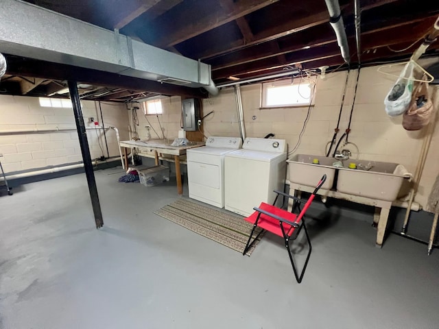 basement featuring washer and dryer, a sink, and electric panel