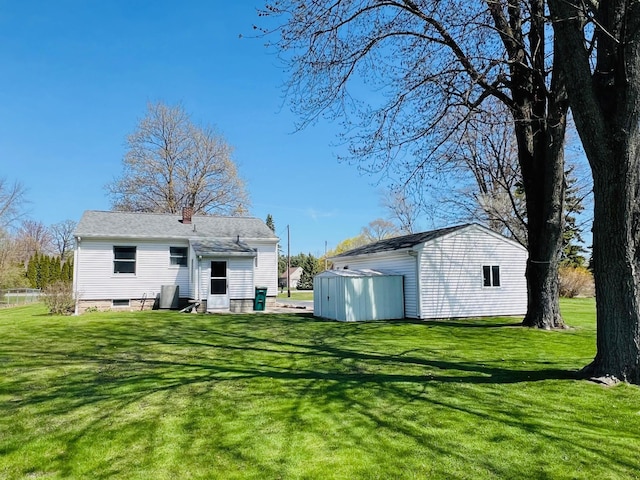 rear view of property with a yard, an outbuilding, a shed, and a chimney