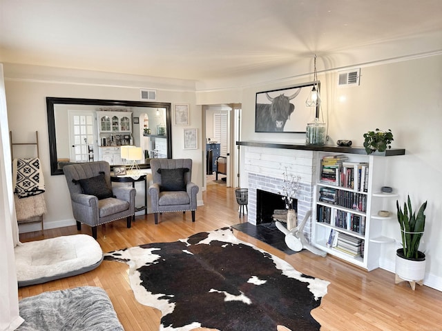living room with visible vents, wood finished floors, and a fireplace