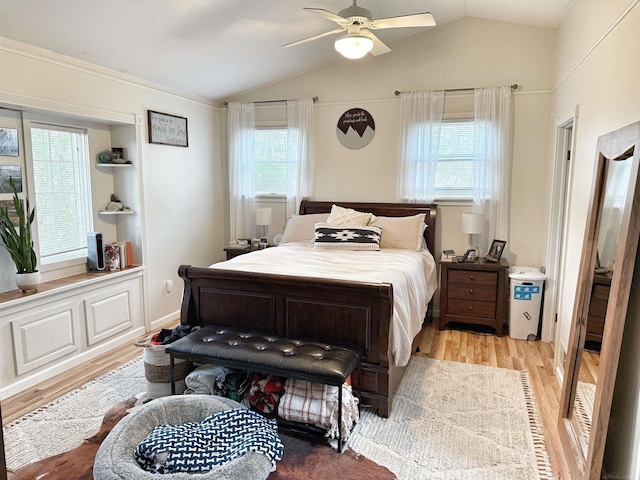 bedroom featuring multiple windows, a ceiling fan, vaulted ceiling, and light wood-style flooring