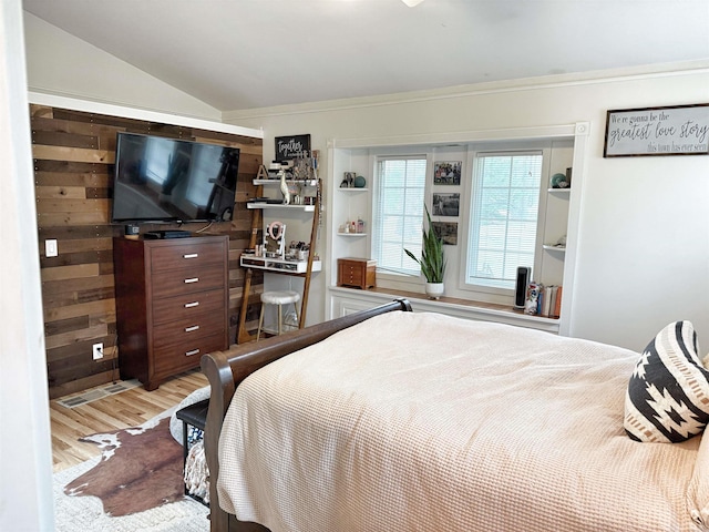 bedroom featuring crown molding, vaulted ceiling, wood finished floors, and a closet